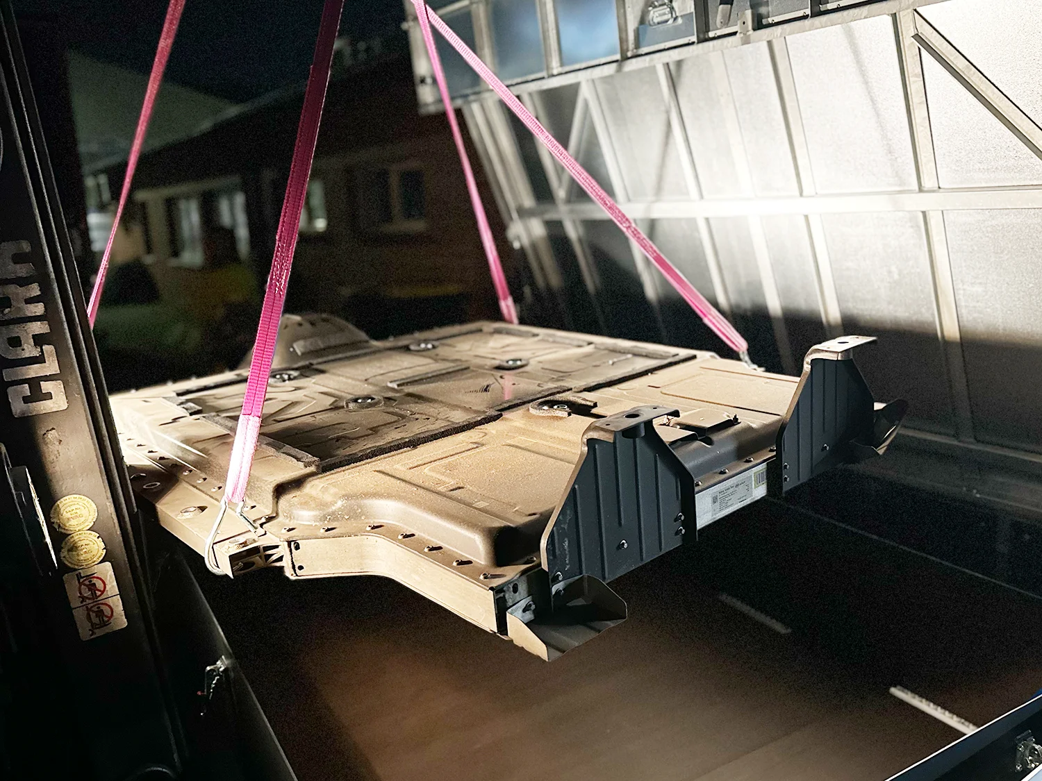 Eine Batterie eines E-Fahrzeugs wird in eine Batteriebox geladen